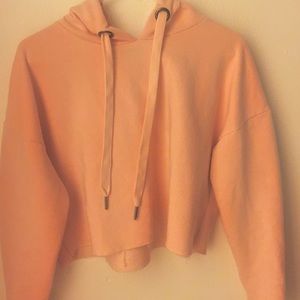 A cropped light pink hoodie